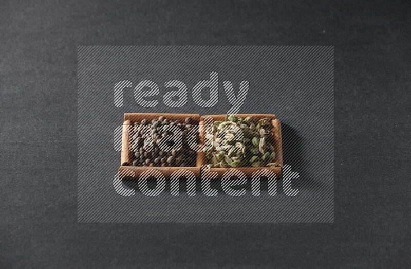 2 squares of cinnamon sticks full of allspice and cardamom on black flooring