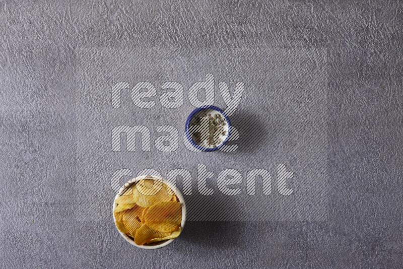 Assorted snacks in pottery bowls on grey background