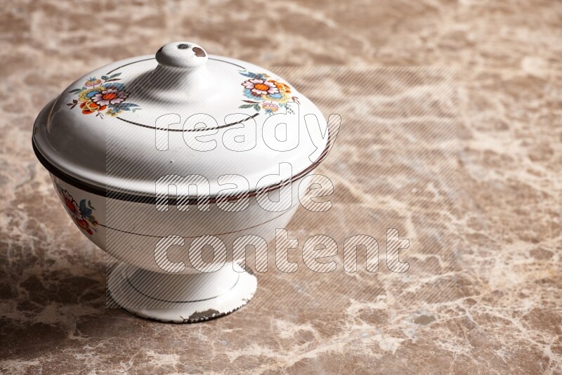 A vintage metal bowl on beige marble background