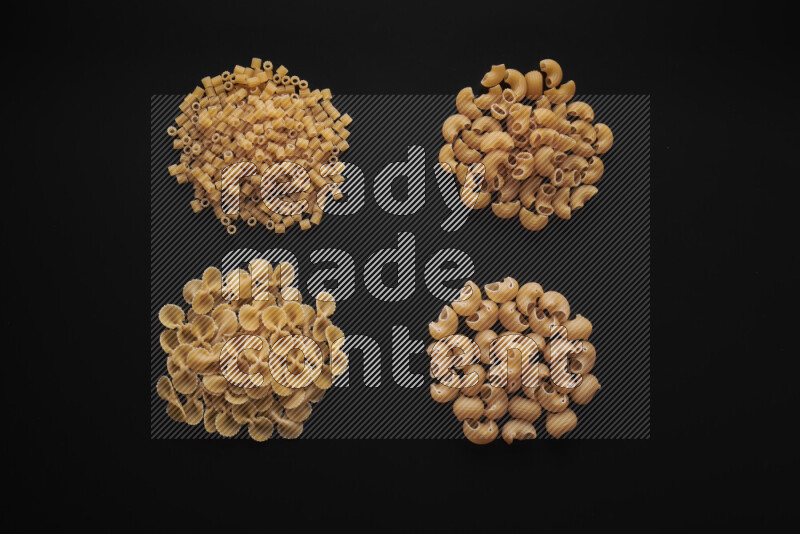 Different pasta types in bunches on black background