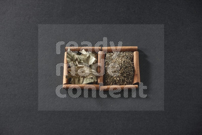 2 squares of cinnamon sticks full of cumin and bay laurel leaves on black flooring