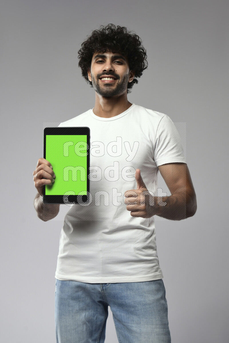 A man wearing casual standing and showing a tablet screen on white background