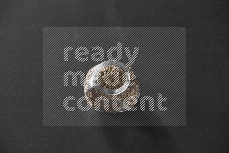 فلفل أبيض في وعاء زجاجي علي خلفية سوداء