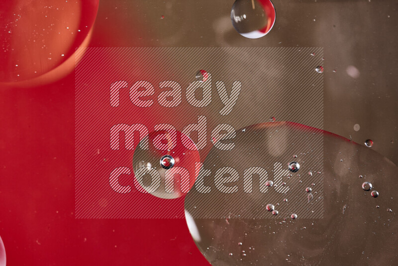 Close-ups of abstract oil bubbles on water surface in shades of red and brown
