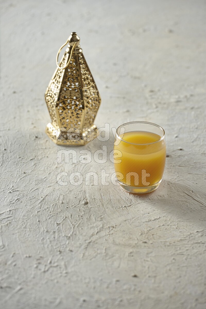 A golden lantern with different drinks, dates, nuts, prayer beads and quran on textured white background