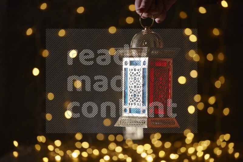 A traditional ramadan lantern surrounded by glowing fairy lights in a dark setup