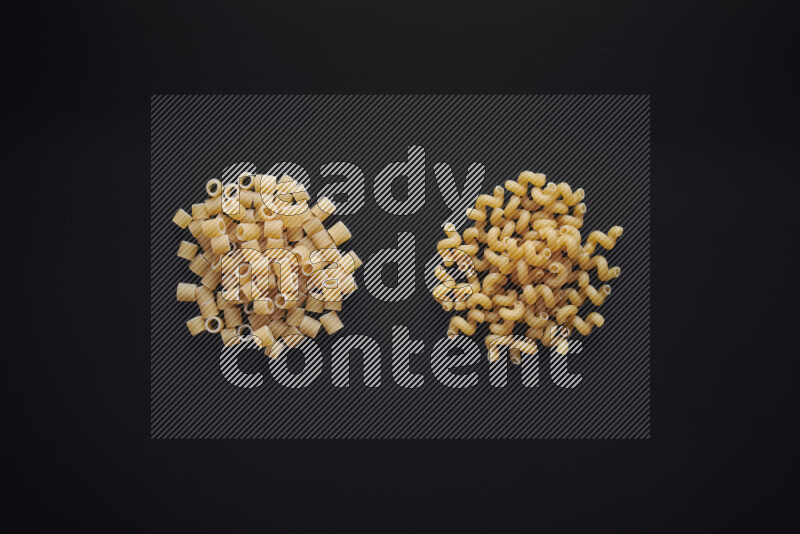 Different pasta types in bunches on black background