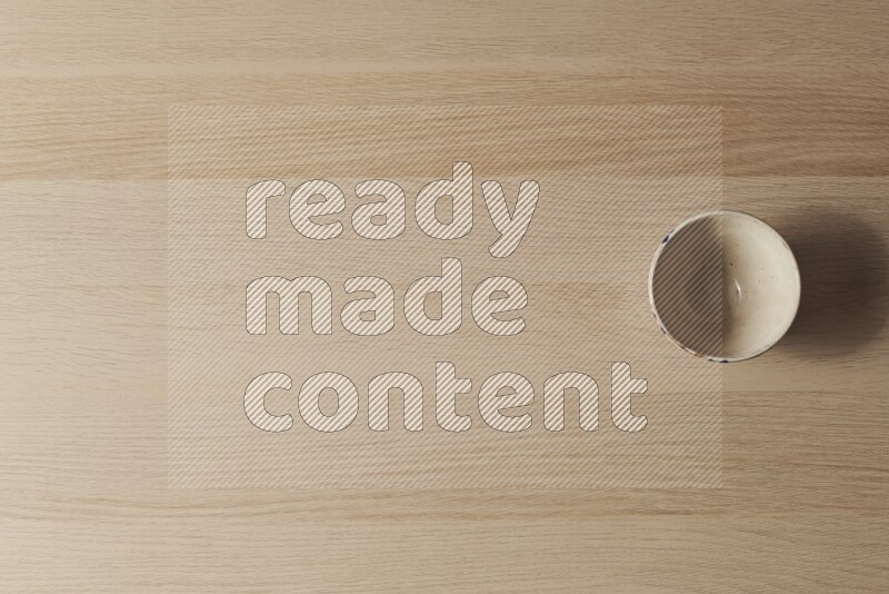 A white pottery bowl on light wooden background