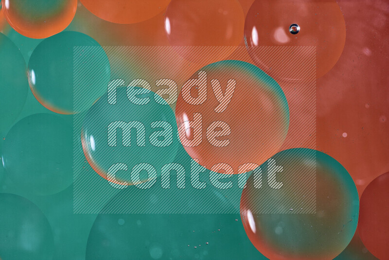 Close-ups of abstract oil bubbles on water surface in shades of green and orange