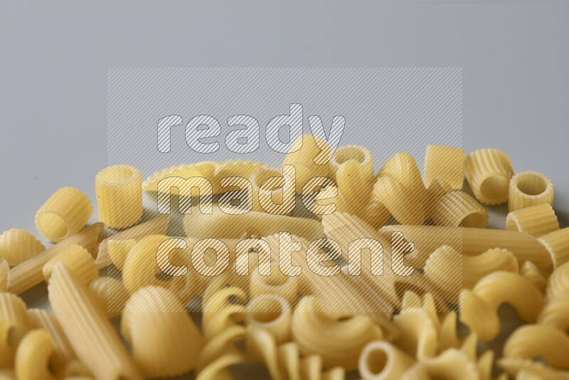 Different pasta types on light blue background