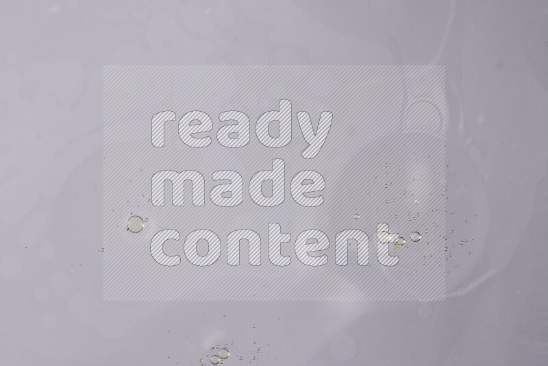 قطرات من الزيت على سطح الماء على خلفية بيضاء