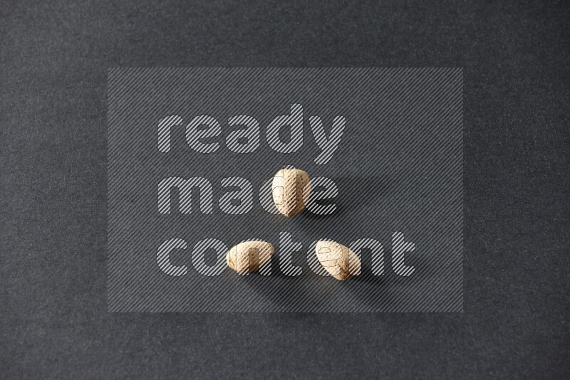 3 almonds on a black background in different angles