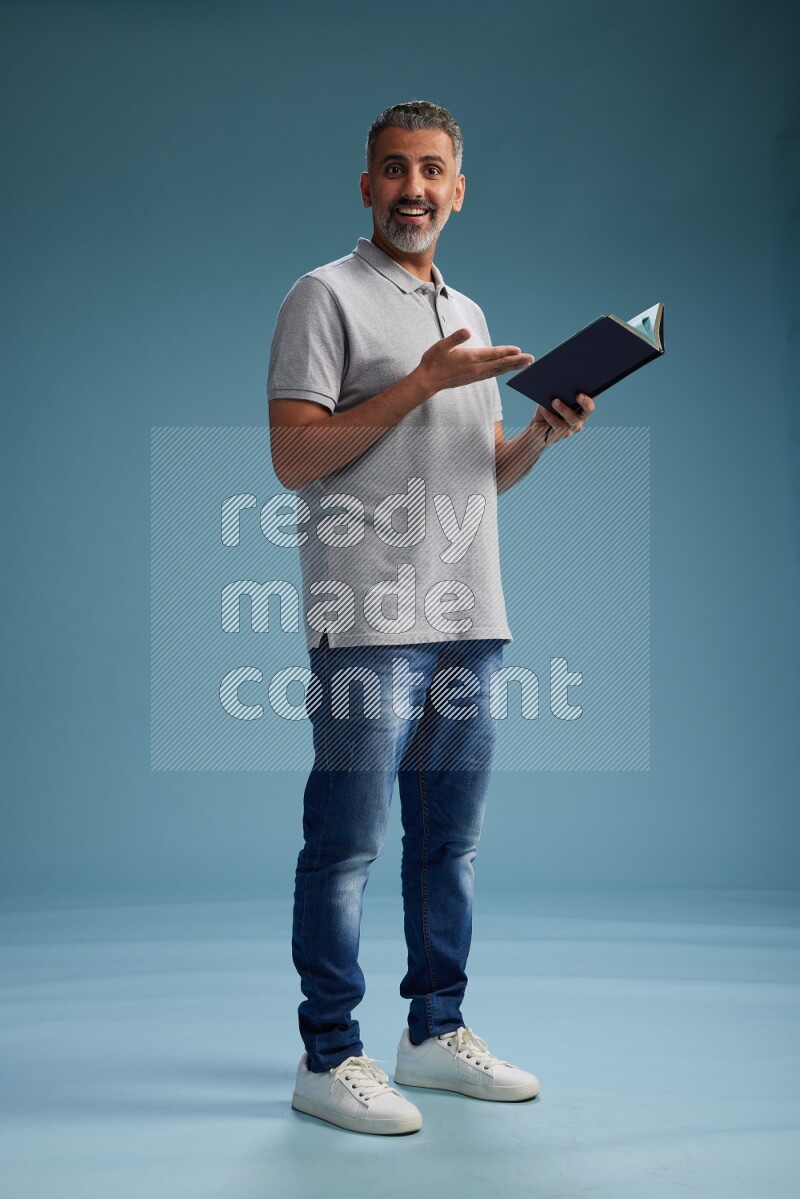 Man Standing reading book on blue background