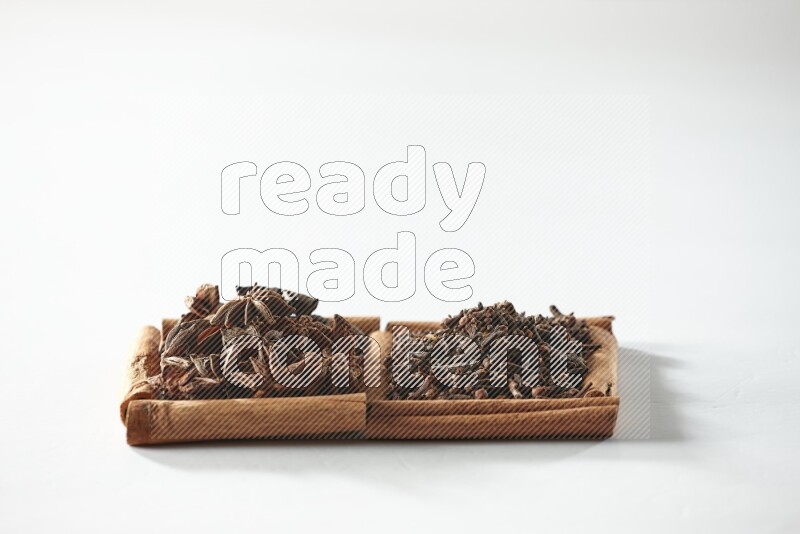 2 squares of cinnamon sticks full of cloves and star anise on white flooring
