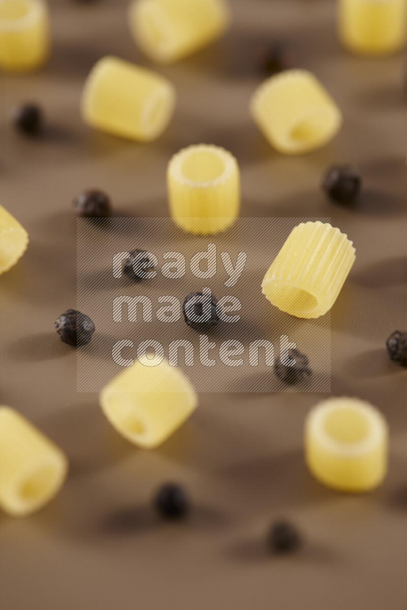 معكرونة مع مكونات متنوعة من الطماطم والثوم والبصل والفلفل الأحمر والفلفل الأسود والفلفل الأبيض وأوراق الغار وإكليل الجبل والهيل على خلفية بيج