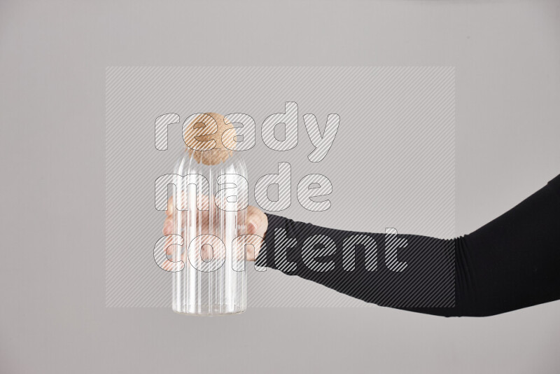 امرأة ترتدي عباءة سوداء تحمل أدوات زجاجية مختلفة في أوضاع متعددة