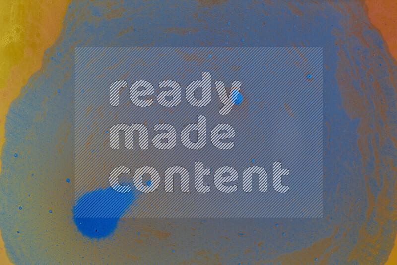 The image captures a dramatic splatter of blue paint over a orange backdrop