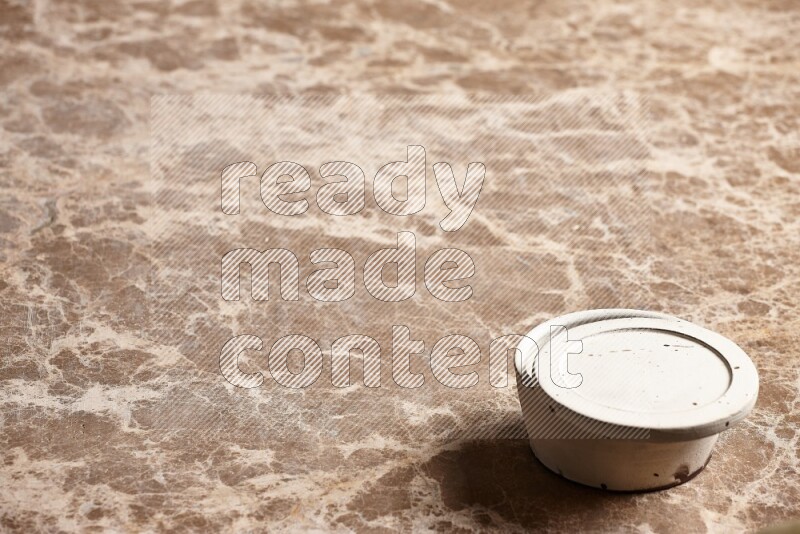 A white pottery bowl on beige marble background