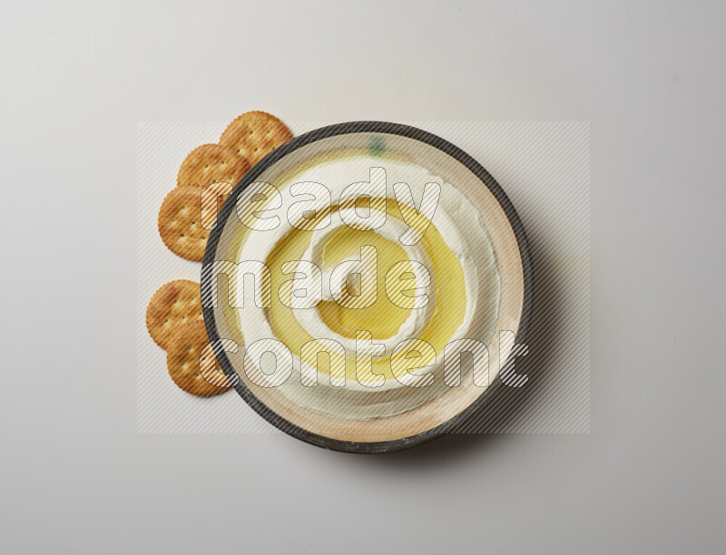 Lebnah garnished with olive oil in a pottery plate on a white background