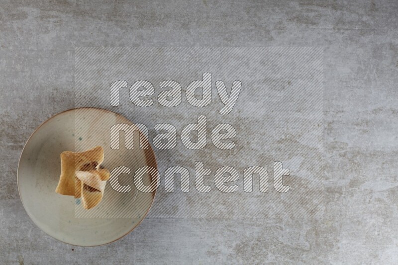 wonton cups with soy sauce ramkin on multi colored pottery on grey textured counter top