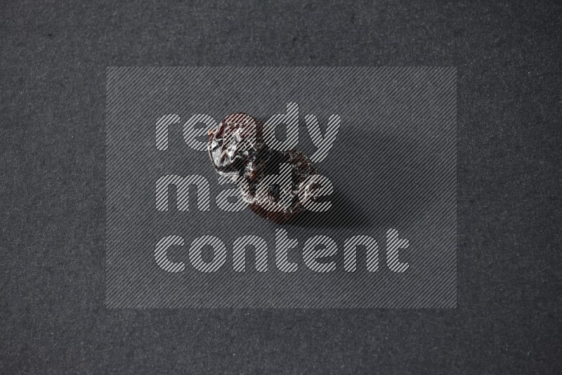 Two dried plums on a black background in different angles