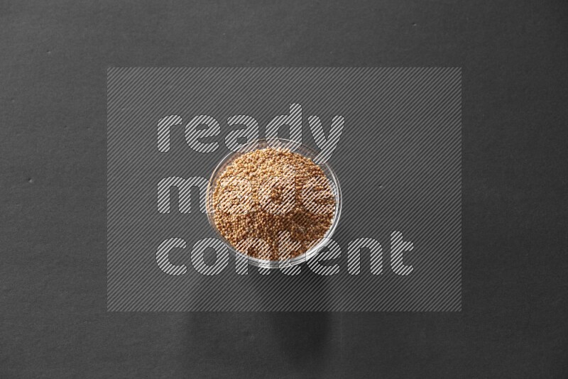 حبوب الخردل في وعاء زجاجي علي خلفية سوداء