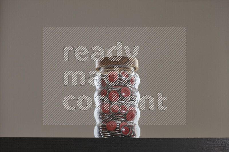 Buttons in a glass jar on black background