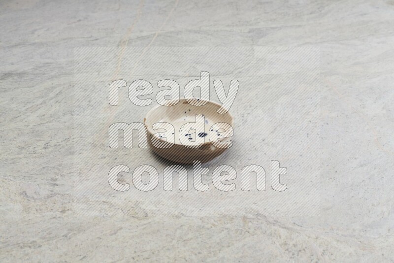 A multicolored pottery bowl on grey marble background