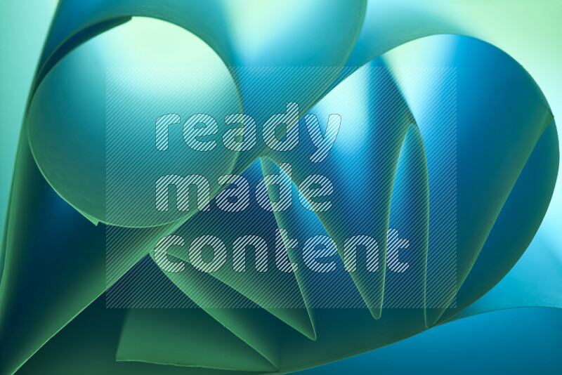 An artistic display of paper folds creating a harmonious blend of geometric shapes, highlighted by soft lighting in green and blue tones