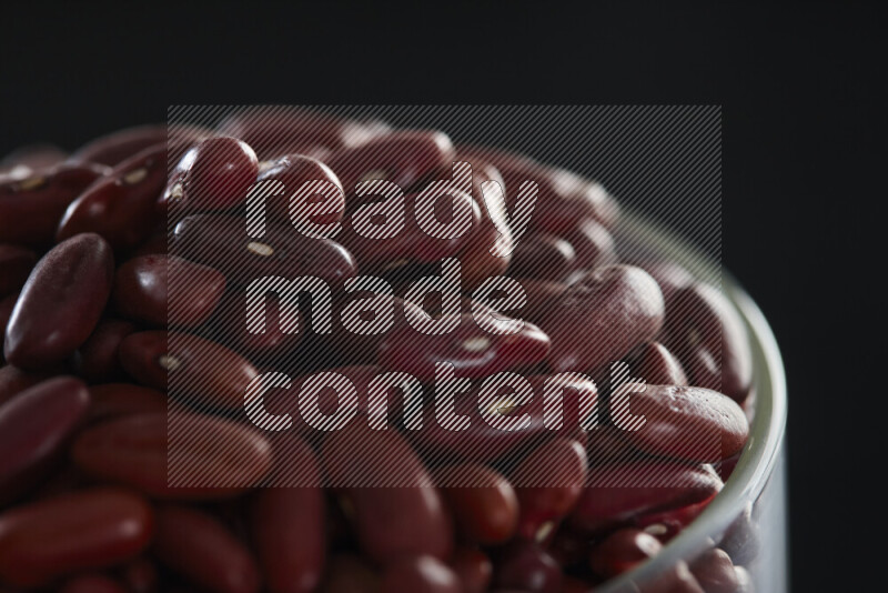 Red kidney beans in a glass jar on black background