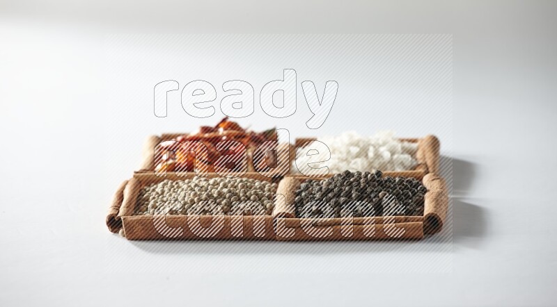 4 squares of cinnamon sticks full of red chilis, salt, white pepper, and black pepper on white flooring