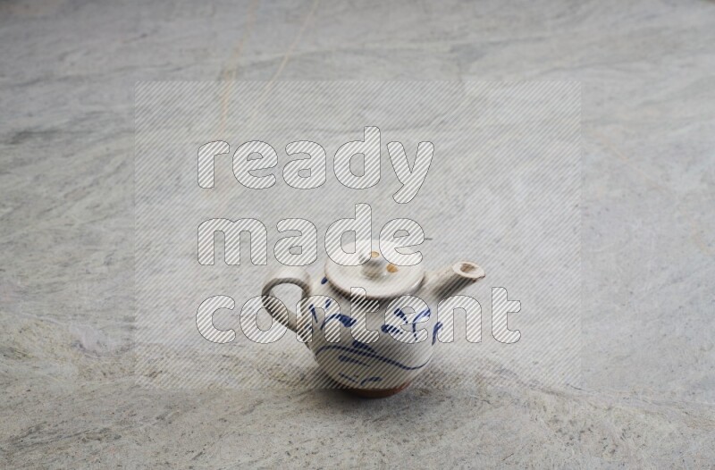 A pottery teapot on grey marble background