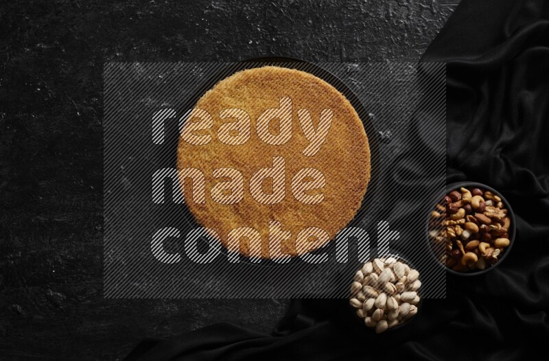 Konafa with nuts and honey in a dark setup