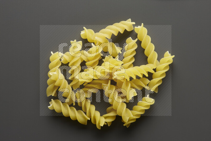 Fusilli pasta on grey background