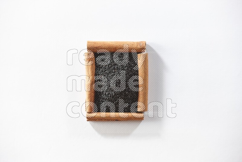A single square of cinnamon sticks full of black seeds on white flooring