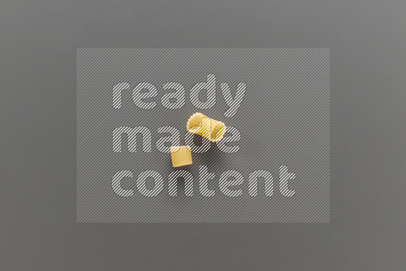 Big rings pasta with other types of pasta on grey background