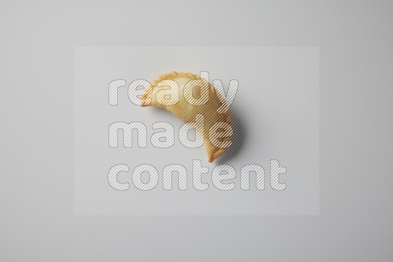 One fried sambosa from a top angle on a white background