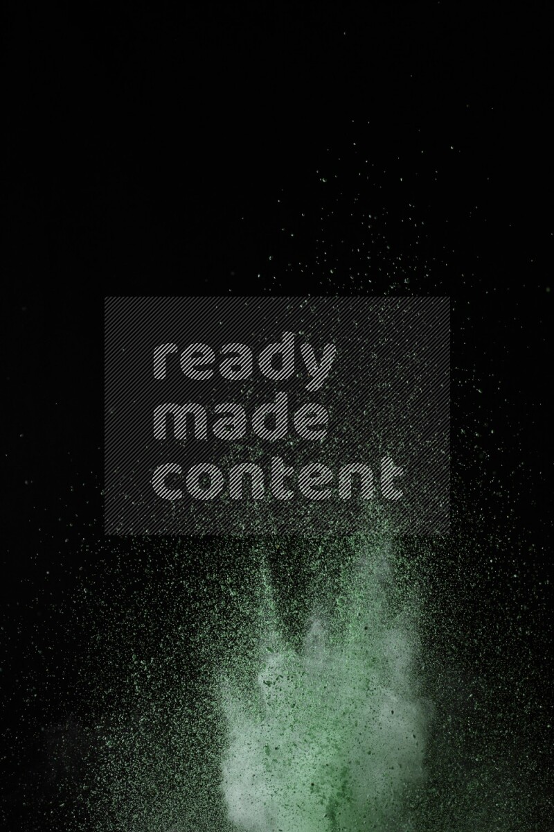 A side view of green powder explosion on black background