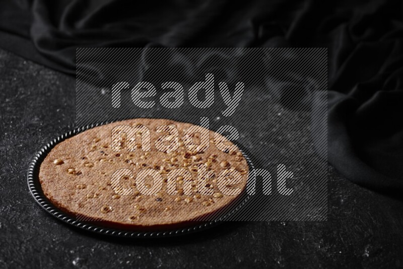 بسبوسة في أطباق مختلفه علي خلفية سوداء خشبية