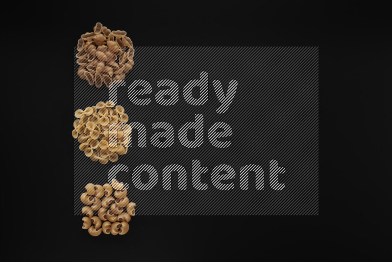 Different pasta types in 3 bunches on black background