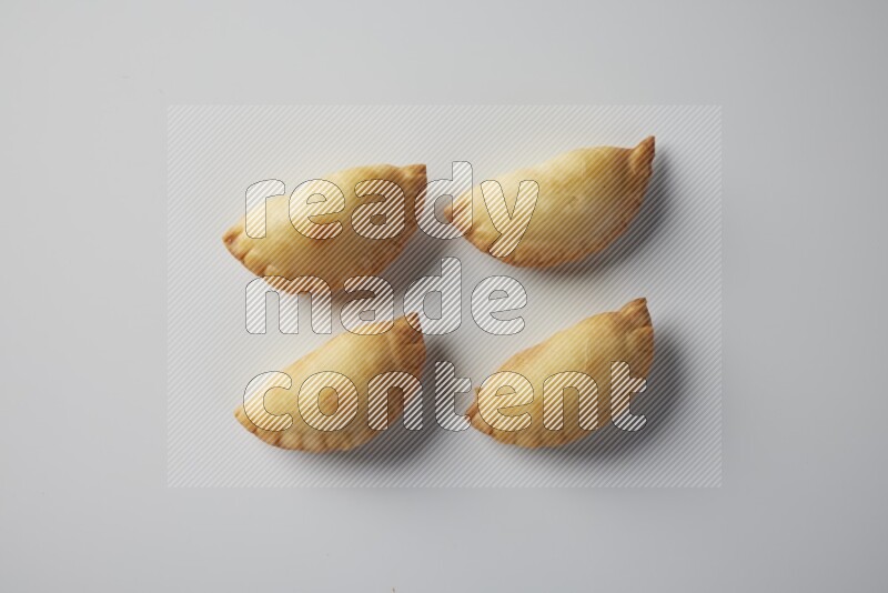Four fried sambosa from a top angle on a white background