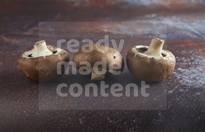 45 degre cremini  mushrooms on a textured reddish rustic metal background