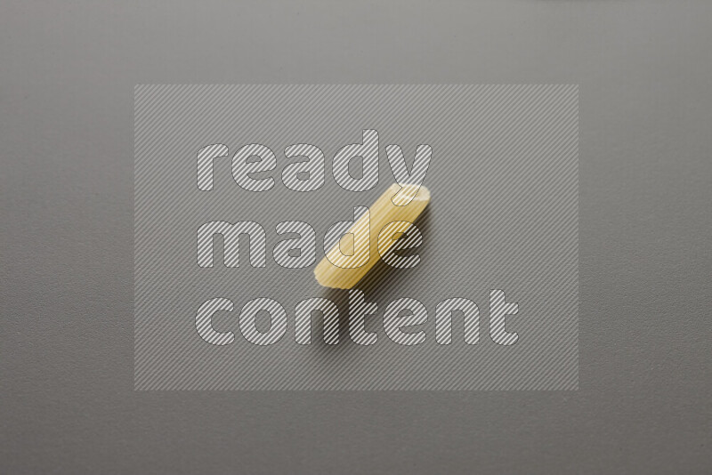 Mini penne pasta on grey background