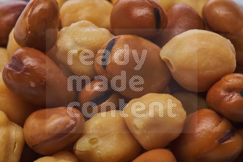 Close up shot of cooked fava beans (foul) & chickpeas on white background