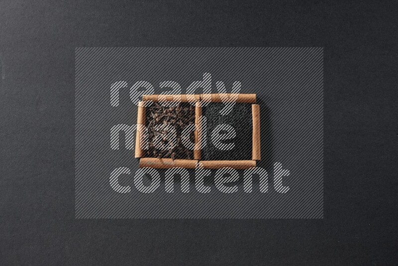 2 squares of cinnamon sticks full of black seeds and cloves on black flooring