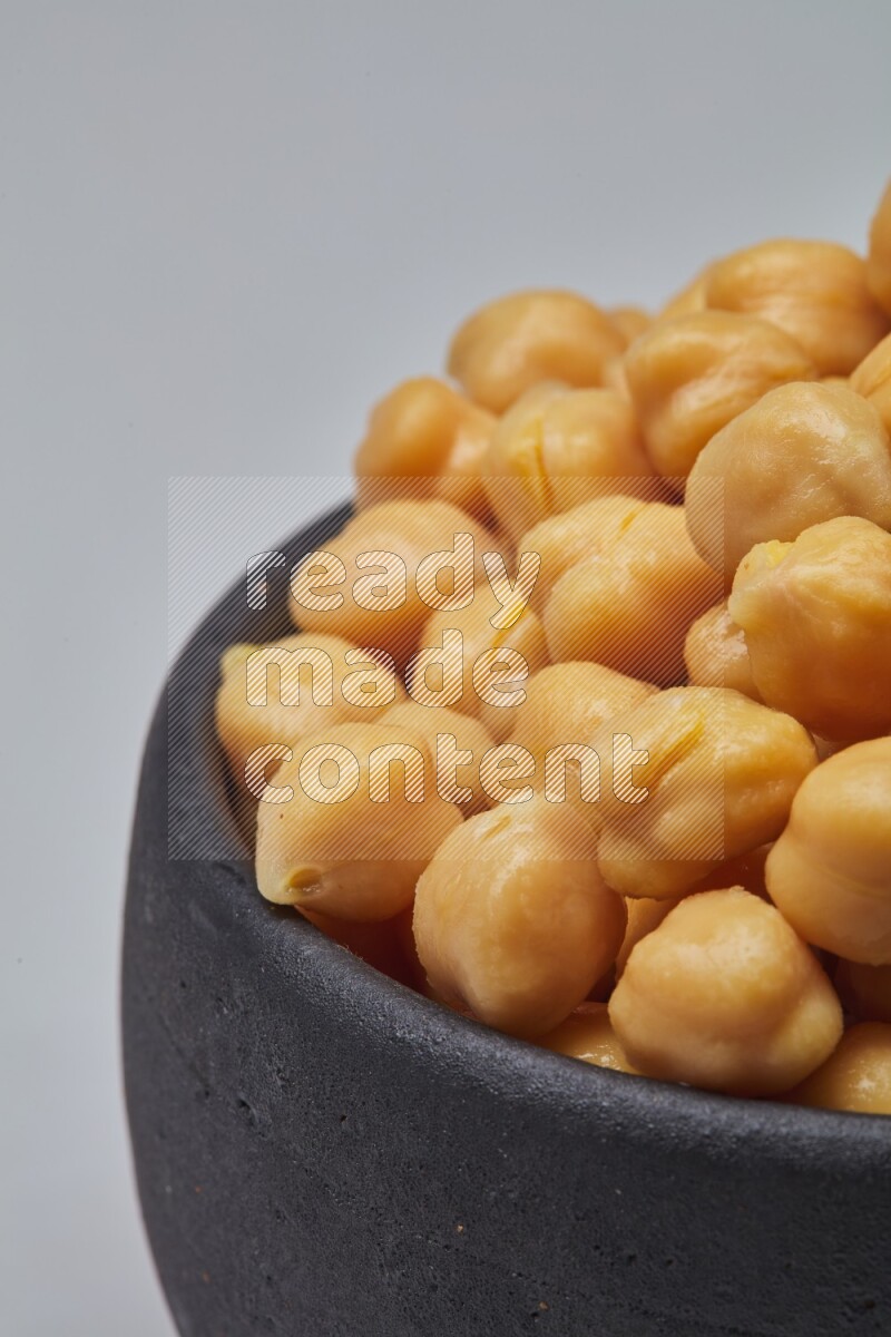 Close up of a boiled chickpeas in a container on white background