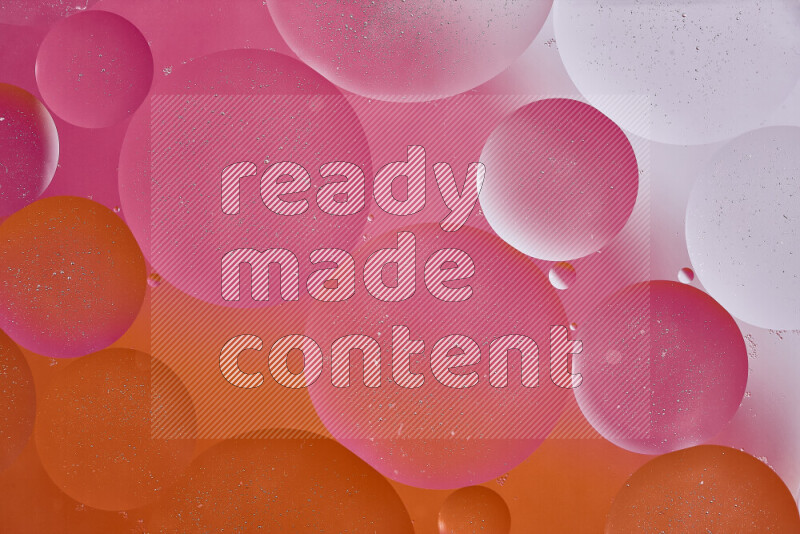 Close-ups of abstract oil bubbles on water surface in shades of white, orange and pink