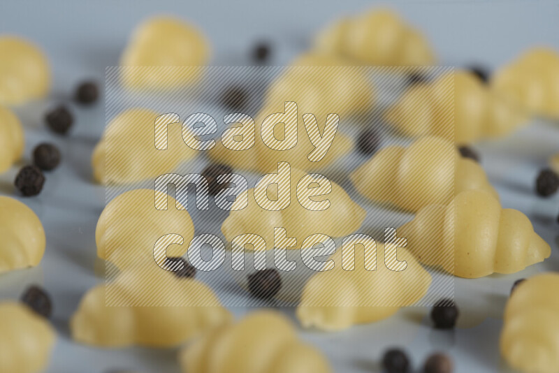 معكرونة مع مكونات متنوعة من الطماطم والثوم والبصل والفلفل الأحمر والفلفل الأسود والفلفل الأبيض وأوراق الغار وإكليل الجبل والهيل و مشروم على خلفية زرقاء فاتحة