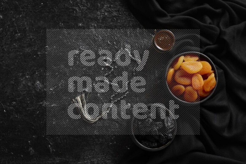 Dried fruits in pottery bowls with coffee in a dark setup