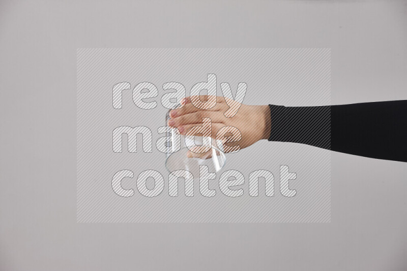 A woman in black abaya holding different glassware in different positions